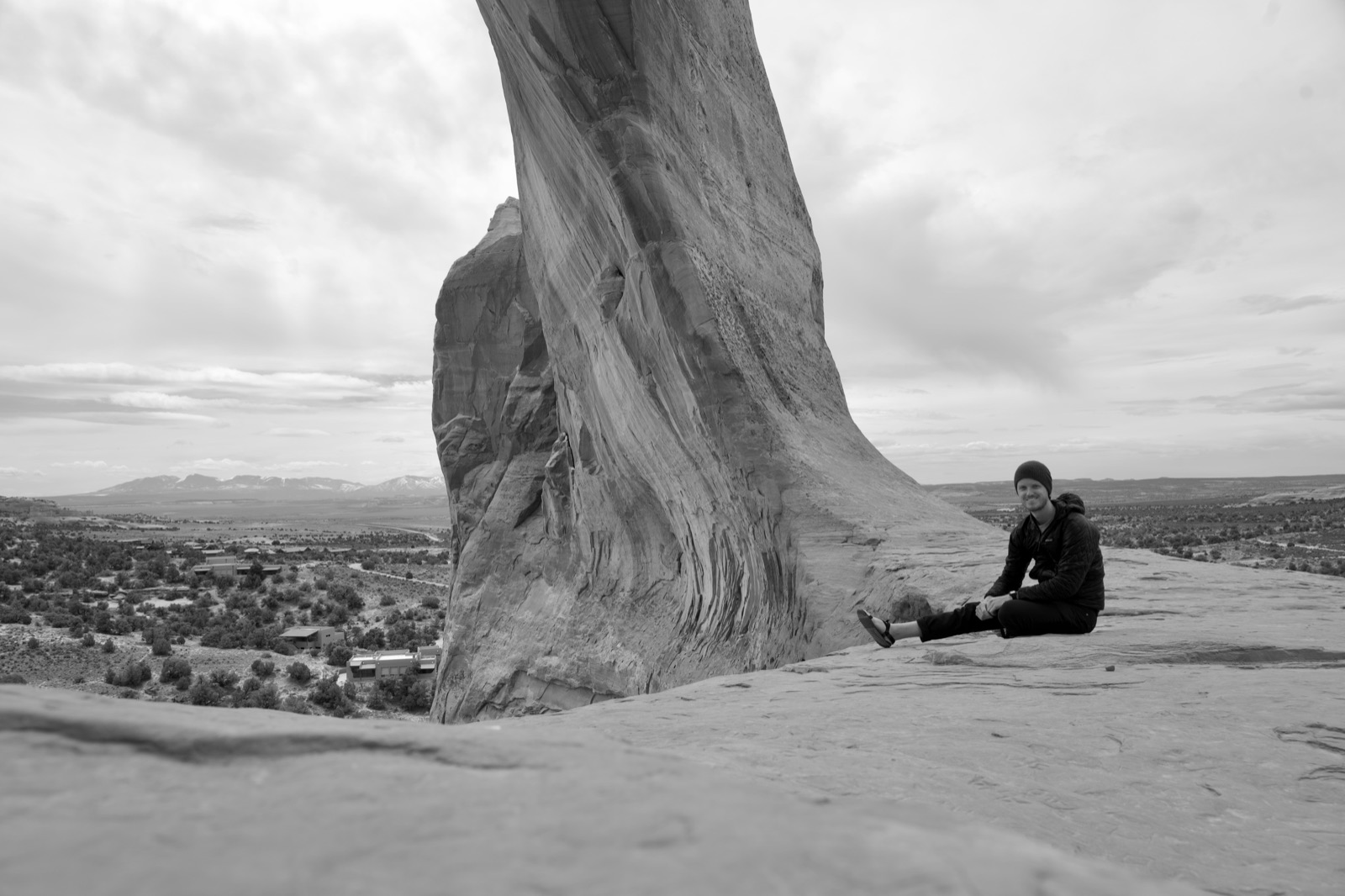 Brian Foshee sitting beneath a sandstone arch near Moab